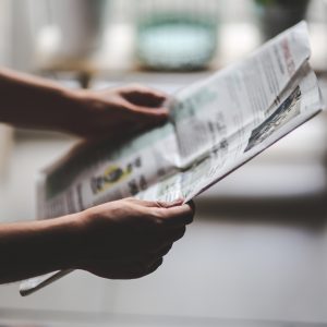 person holding newspaper reading